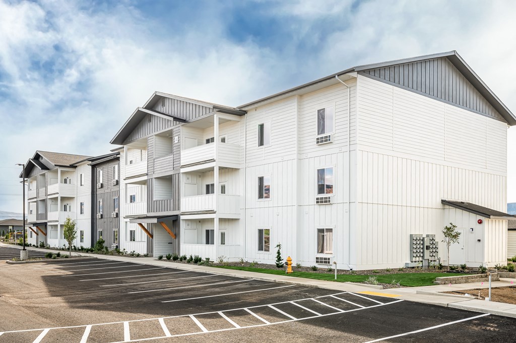 a white building with a parking lot in front of it at Gateway Apartments, East Wenatchee , WA