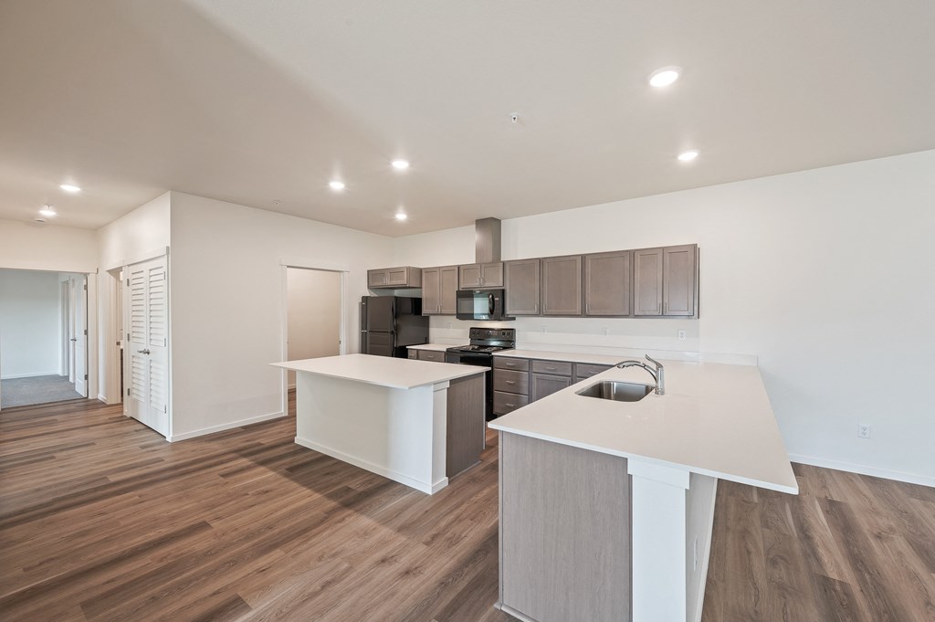a kitchen with a white counter top and a stainless steel refrigerator at Gateway Apartments, East Wenatchee ,Washington, 98802
