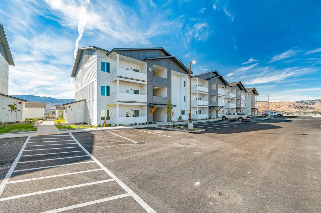 an empty parking lot at an apartment complex with a blue sky at Gateway Apartments, East Wenatchee