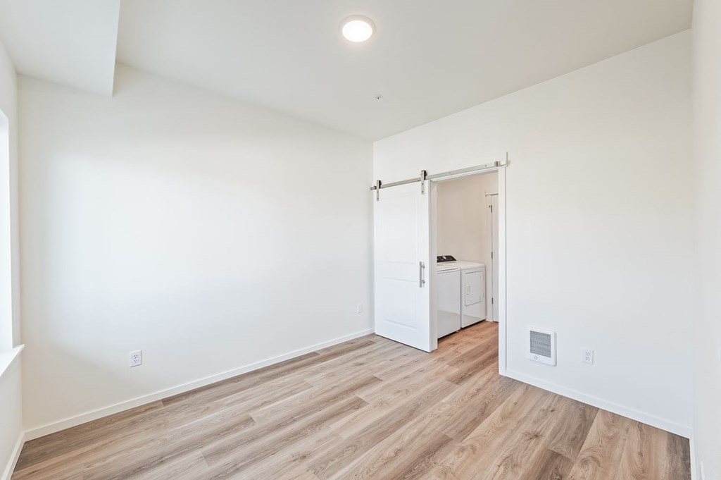 a bedroom with white walls and wood flooring and a closet at Gateway Apartments, East Wenatchee , WA