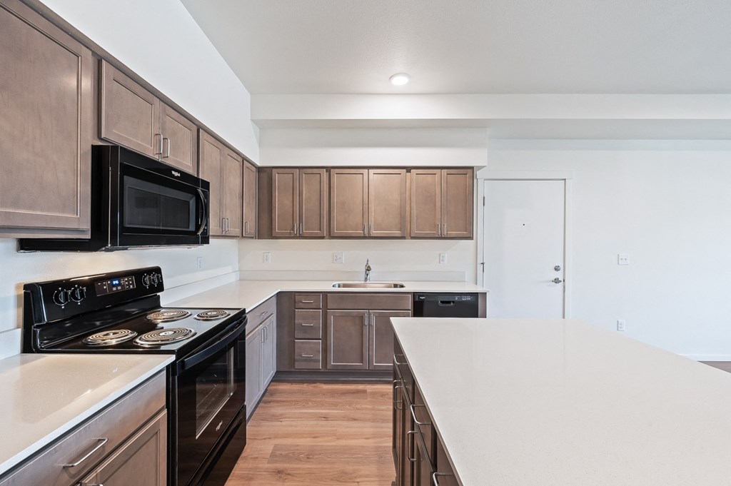 a kitchen with a white counter top and wooden cabinets at Gateway Apartments, East Wenatchee ,Washington, 98802