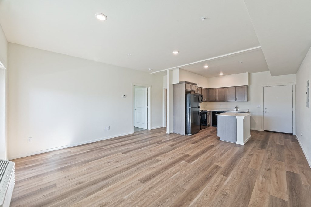 an empty living room and kitchen with wood flooring at Gateway Apartments, Washington, 98802