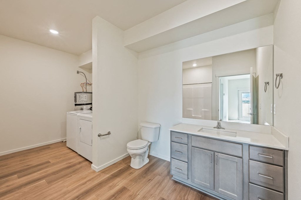 a bathroom with a sink toilet and a mirror at Gateway Apartments, East Wenatchee