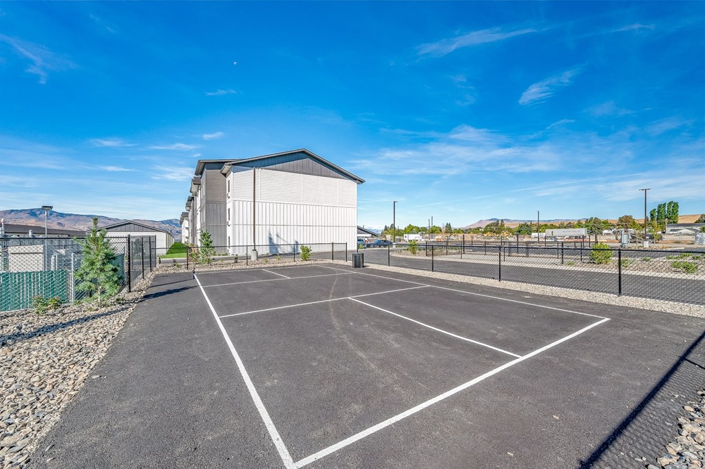 an empty parking lot with a building in the background at Gateway Apartments, East Wenatchee ,Washington, 98802