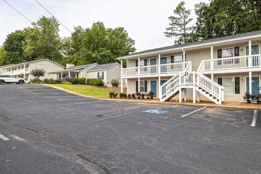 A parking lot in front of a building with a car parked at Overlook Club Apartments, Cummings, 30040