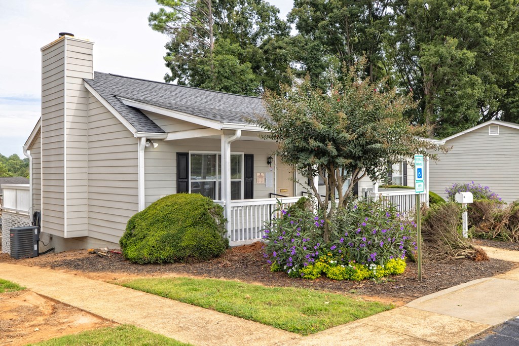 A small house with a well-kept front yard at Overlook Club Apartments, Cummings, GA, 30040