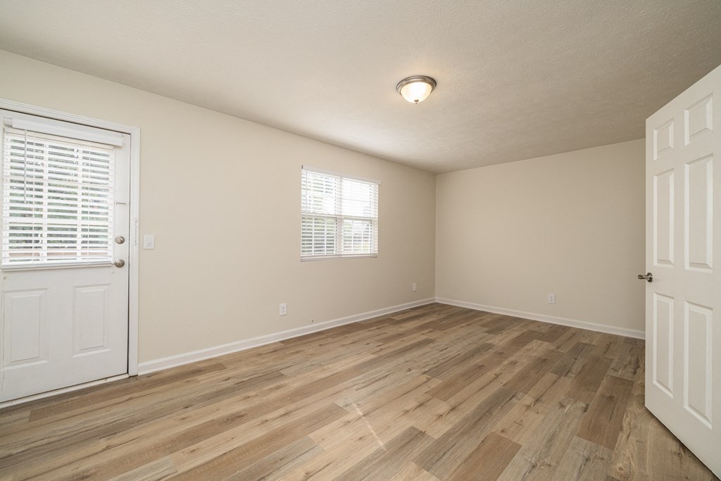 A room with wooden flooring and a window with blinds at Overlook Club Apartments, Cummings, GA