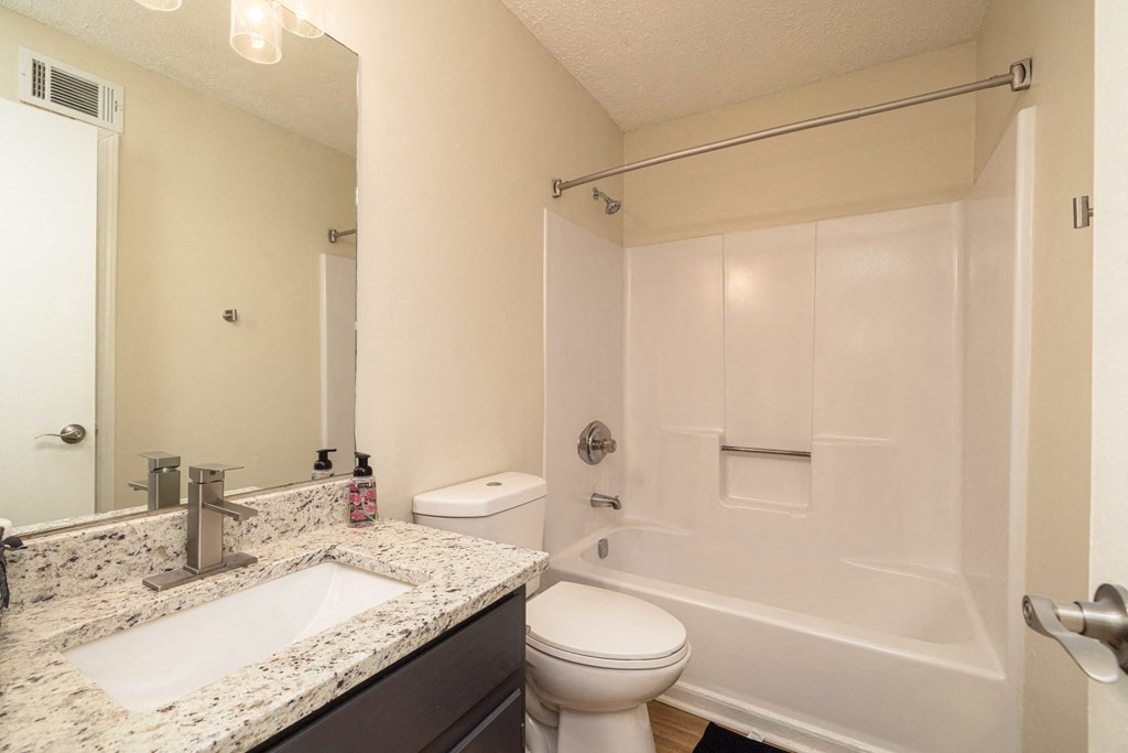 A white bathroom with a sink, toilet, and bathtub at Overlook Club Apartments, Georgia 30040