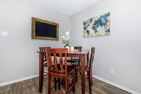 A dining room with a wooden table and chairs.