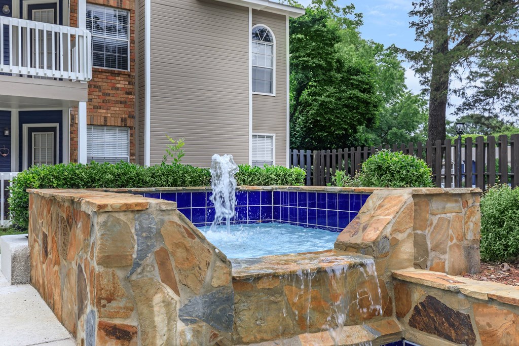a pool with a fountain in front of a house at The Davis Apartments, Alabama  