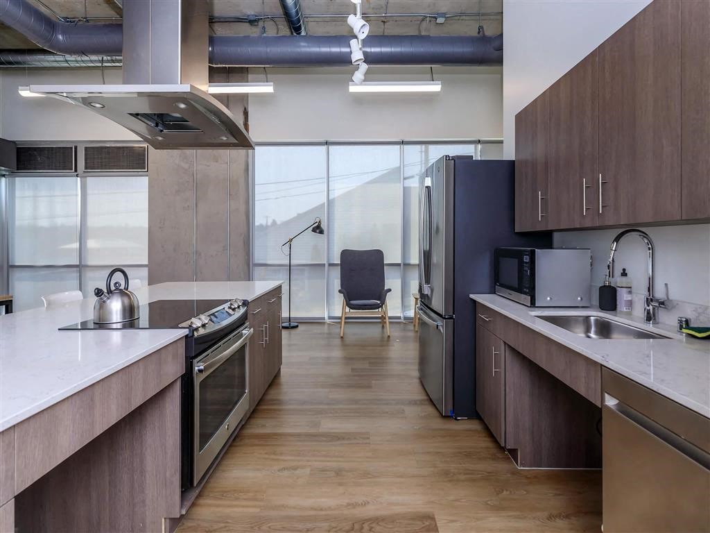 a kitchen with a stove top oven next to a sink at Jefferson Yards, Tacoma, WA