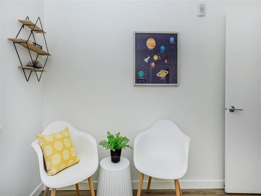 a living room with two white chairs and a small table with a plant on top of it at Jefferson Yards, Washington