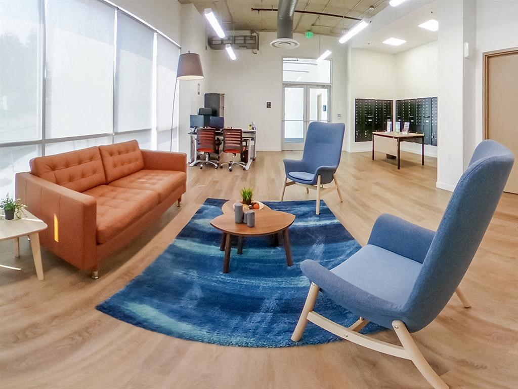 a living room with blue chairs and a brown couch at Jefferson Yards, Washington, 98402