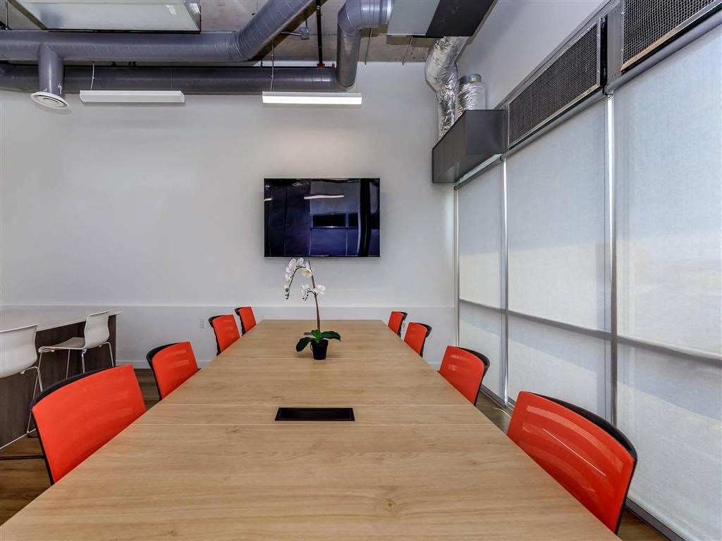 a conference room with a long table and orange chairs at Jefferson Yards, Tacoma Washington