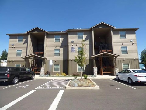 Three story apartment building with covered entryways and parking at Waln Creek Apartments, Oregon