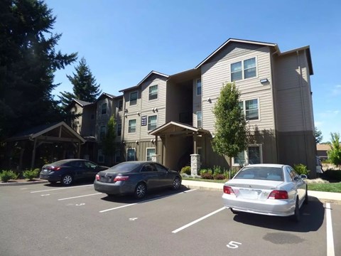 A parking lot with cars and apartment buildings in the background.