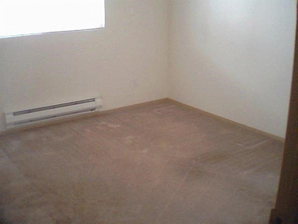 an empty room with a heater on the floor