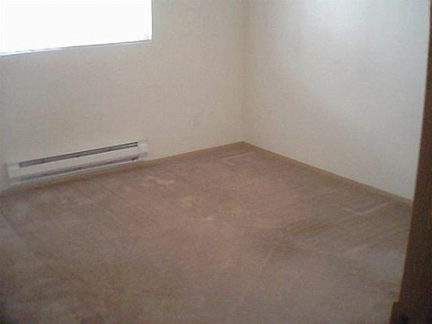 an empty room with a heater on the floor