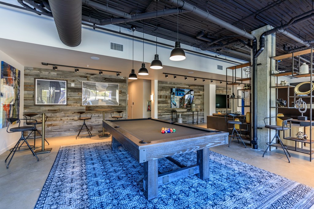 a pool table sits in the middle of a room with a bar in the background a pool table sits in the middle of a room with a bar in the background at Napoleon Apartments, Tacoma, 98402