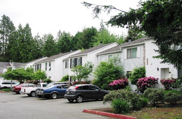 a row of houses with cars parked in a parking lot