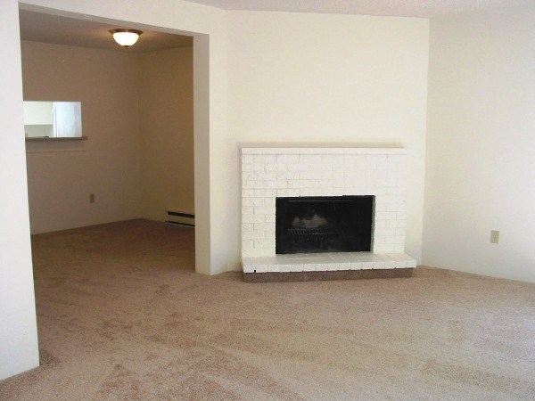 an empty living room with a fireplace in it