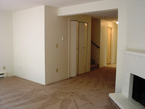 an empty living room with a fireplace