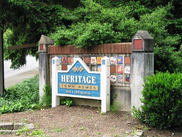 a sign for the heritage town house     in front of a fence
