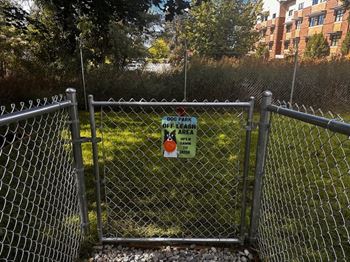 A sign on a fence indicates that the park is off-leash at Ironwood Apartments, Coeur d'Alene, ID