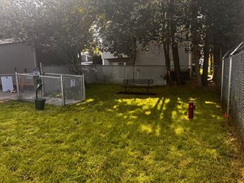 A backyard with a fence, a fire hydrant, and a picnic table at Ironwood Apartments, Coeur d'Alene, ID, 83814