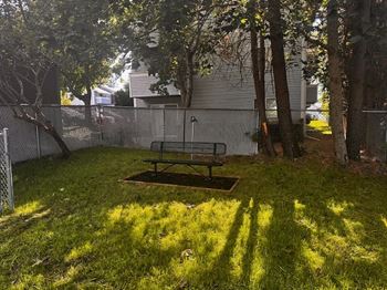 A backyard with a picnic table and a fence. at Ironwood Apartments, Coeur d'Alene, ID, 83814