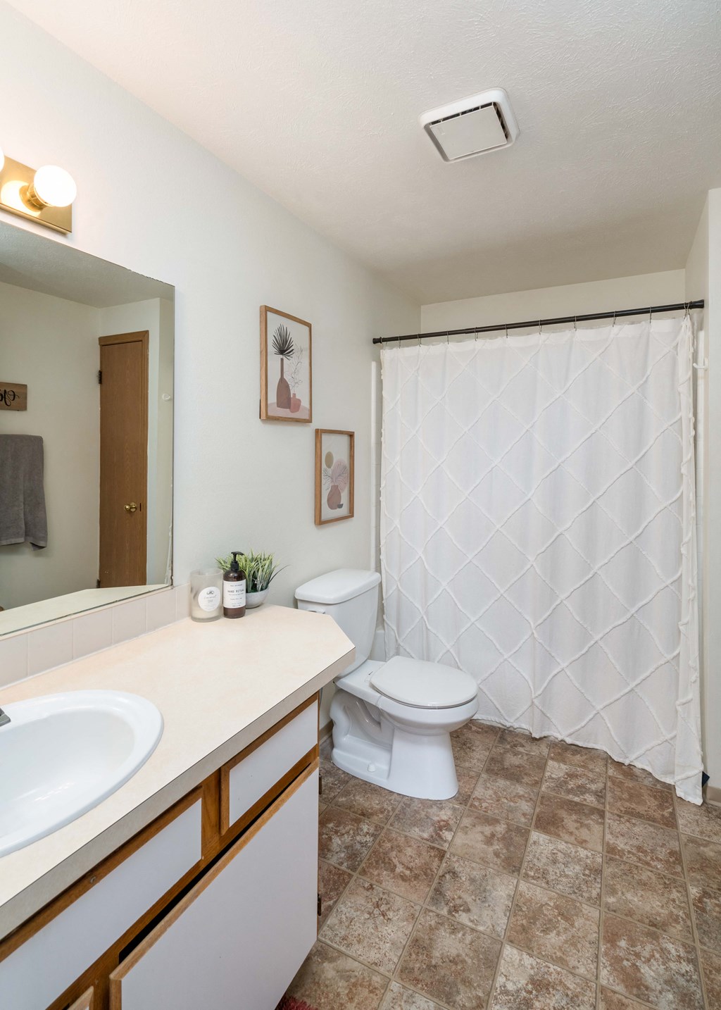 a bathroom with a white sink and toilet next to a white shower curtain  at Ironwood Apartments, Coeur d'Alene