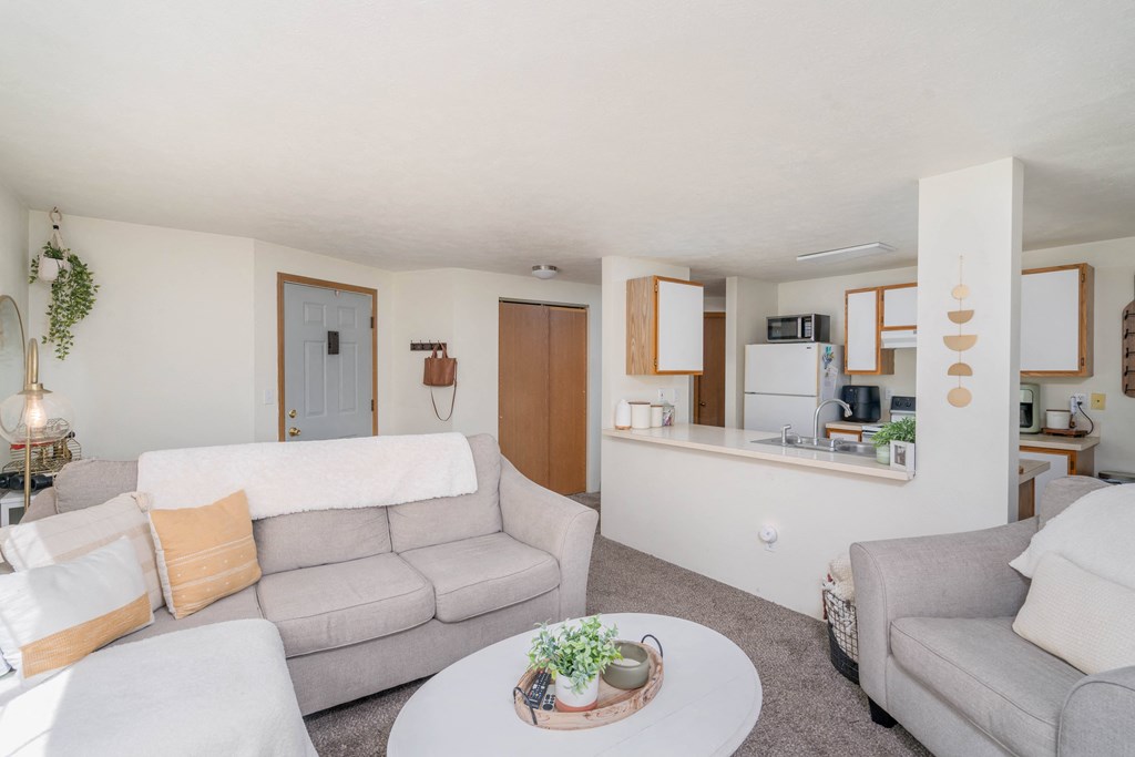 a living room with couches a table and a chair and a kitchen in the background  at Ironwood Apartments, Coeur d'Alene, ID