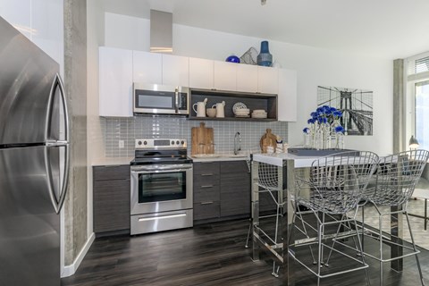 a kitchen with stainless steel appliances and a table with chairs