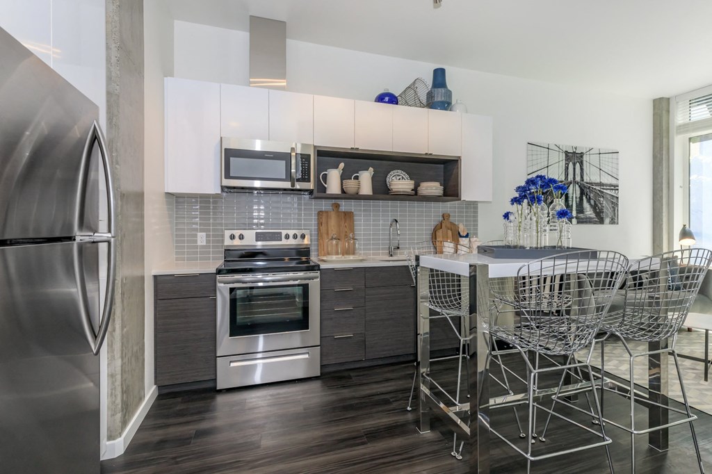 a kitchen with white cabinets and stainless steel appliances a kitchen with white cabinets and stainless steel appliances at Napoleon Apartments, Tacoma