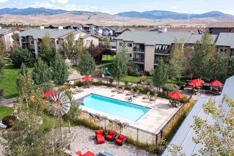Aerial view of pool area with mountain backdrop at Mullan Reserve Apartments, Montana