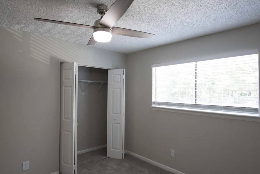 A room with a ceiling fan and a window with blinds at The Madison Apartments and Townhomes, Georgia 30044