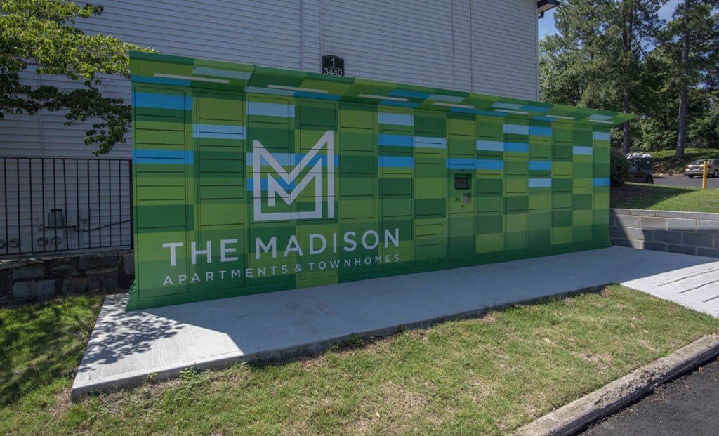 A green and blue sign for The Madison Apartments & Townhomes at The Madison Apartments and Townhomes, Lawrenceville, GA, 30044