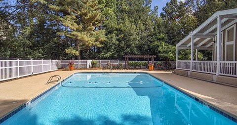 A rectangular pool with a white fence around it.
