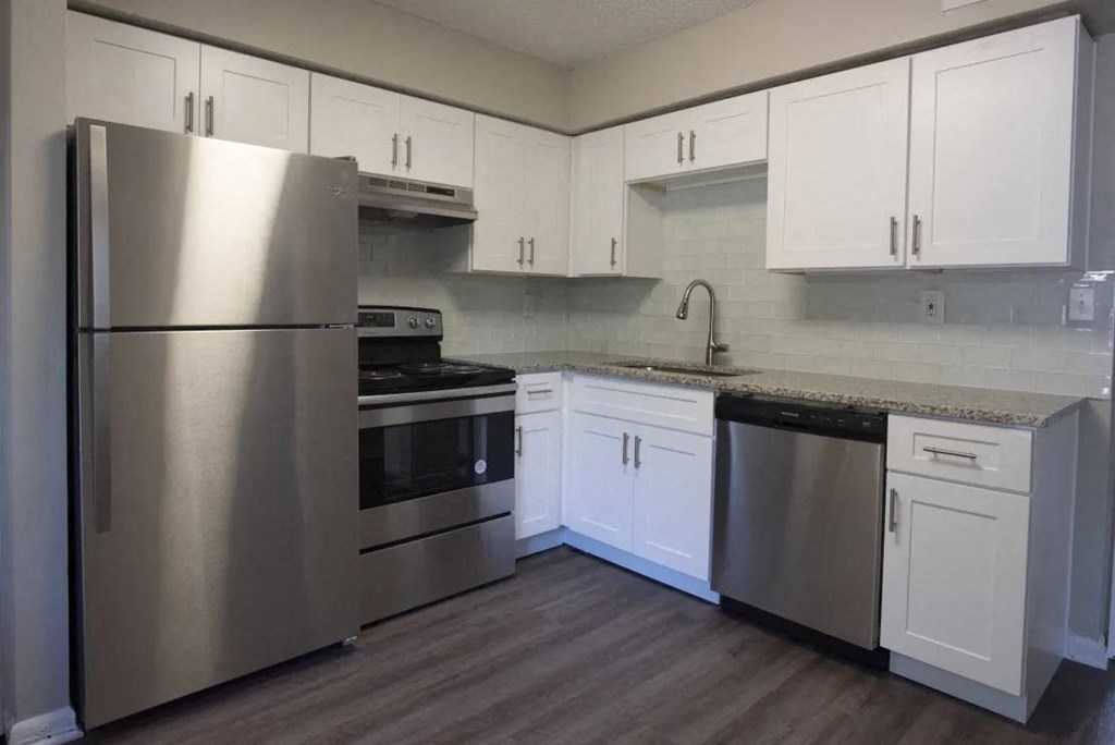 A kitchen with a stainless steel refrigerator, oven, and dishwasher at The Madison Apartments and Townhomes, Lawrenceville