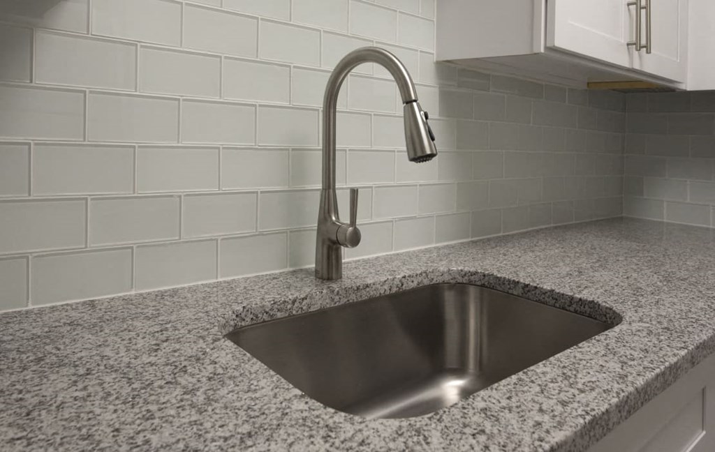 A modern kitchen sink with a chrome faucet at The Madison Apartments and Townhomes, Georgia