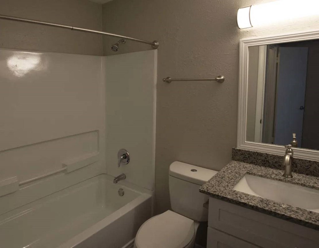 A bathroom with a toilet, sink, and bathtub at The Madison Apartments and Townhomes, Lawrenceville, Georgia