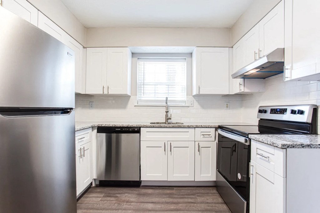 A kitchen with white cabinets and a stainless steel refrigerator at Barcelo at East Cobb Apartments, GA, 30067