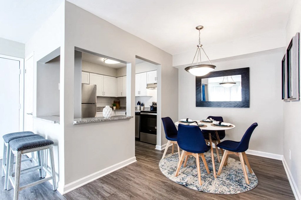A kitchen with a bar stool and a dining table with chairs at Barcelo at East Cobb Apartments, Georgia