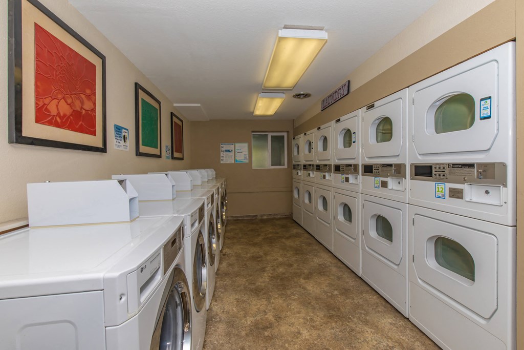 a washer and dryer room with a row of washing machines and laundry facilities at Lincoln Village Apartments, Spokane, WA 99208