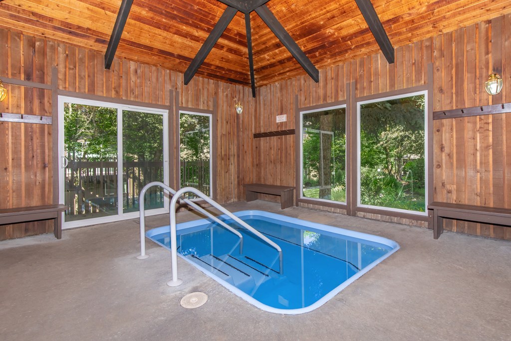 a resort style swimming pool with a wooden ceiling and concrete flooring at Lincoln Village Apartments, Spokane, WA