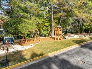 A playground with a basketball hoop and a slide.at Waverly Manor Townhomes, Norcross, GA 30071