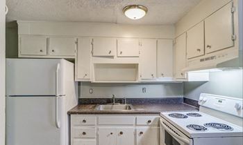 A kitchen with white appliances and cabinets.at Waverly Manor Townhomes, Norcross, 30071