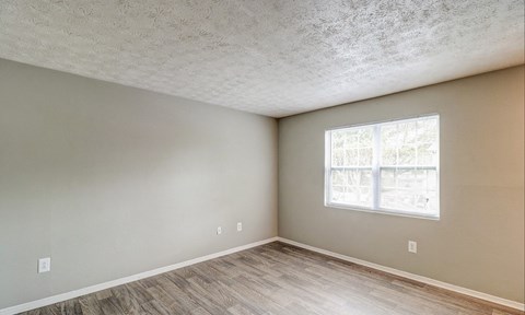 A room with a window and wooden flooring.at Waverly Manor Townhomes, Norcross Georgia