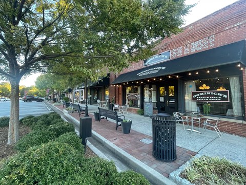A street view of a city with a restaurant named Positano's.at Waverly Manor Townhomes, Norcross, 30071