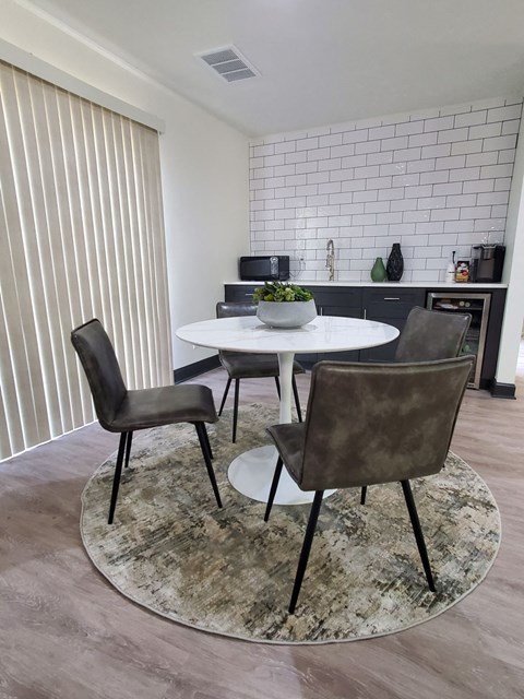 A dining room with a white table and chairs.